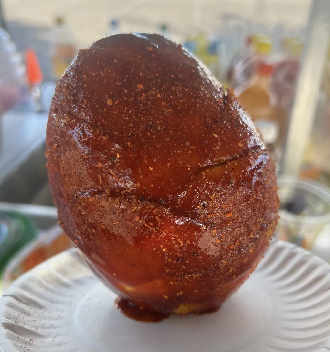Mango entero pelado cubierto de chamoy y Tajín en un plato