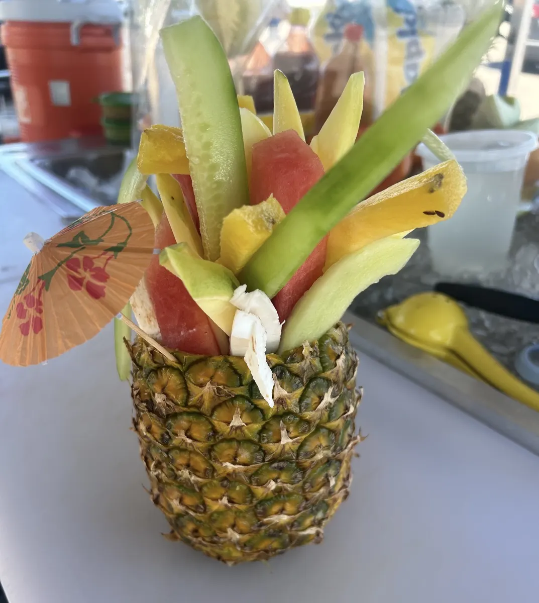 Piña rellena con tiras de pepino, sandía, mango, melón y coco con sombrillita